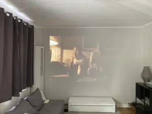 Optoma UHZ50 Projektion im Wohnzimmer mit vorderer Abdunklung